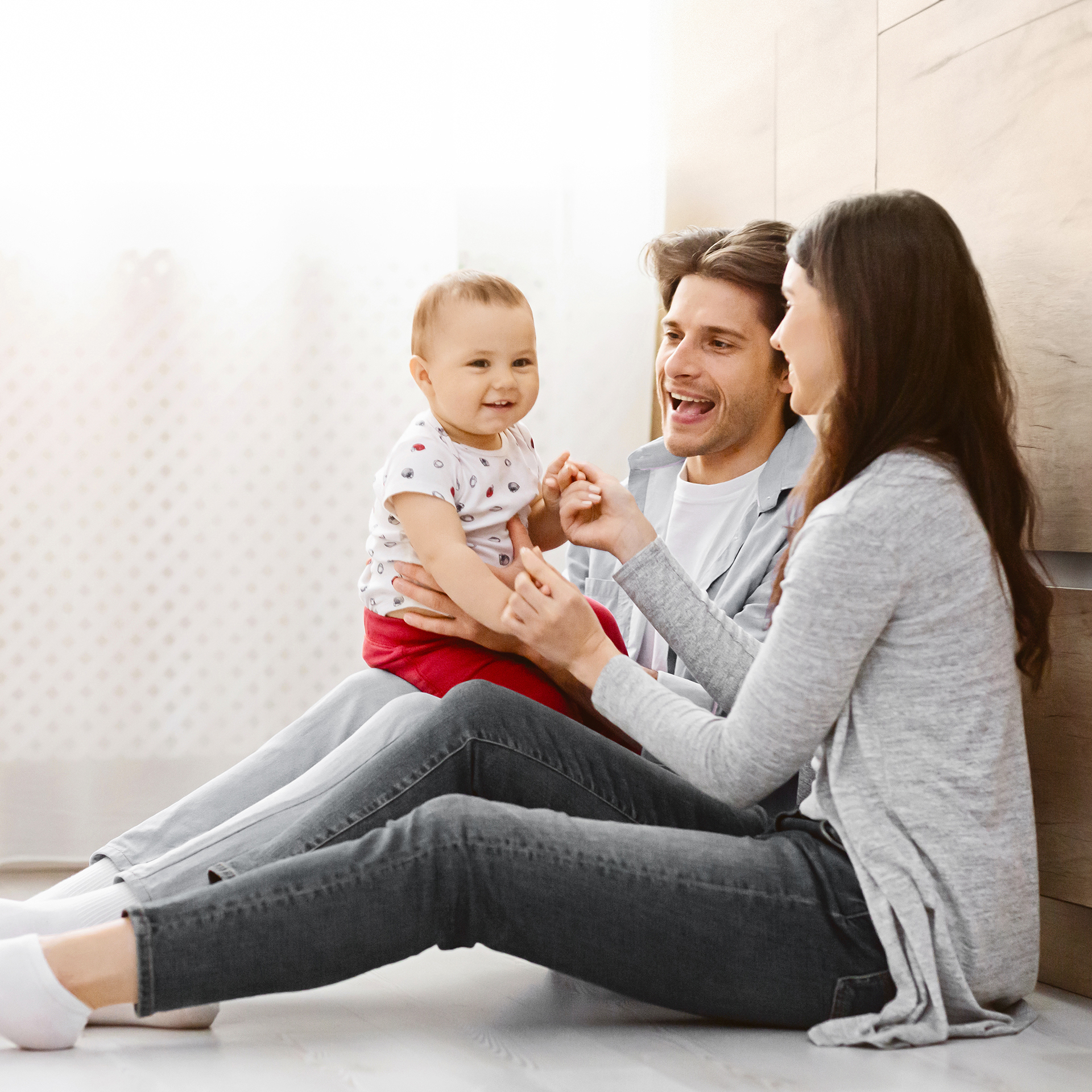 Happy Family Sitting on Floor in Modern Home Interior