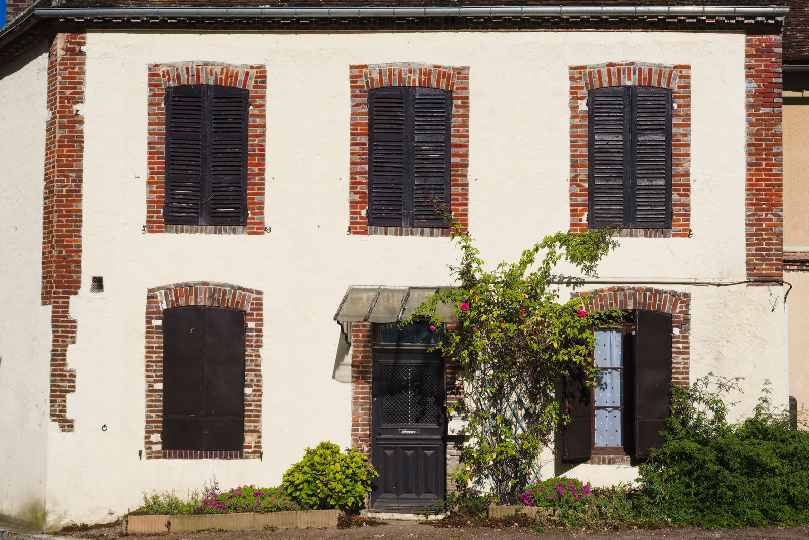 Façade d’une maison ancienne avec volets en bois à rénover